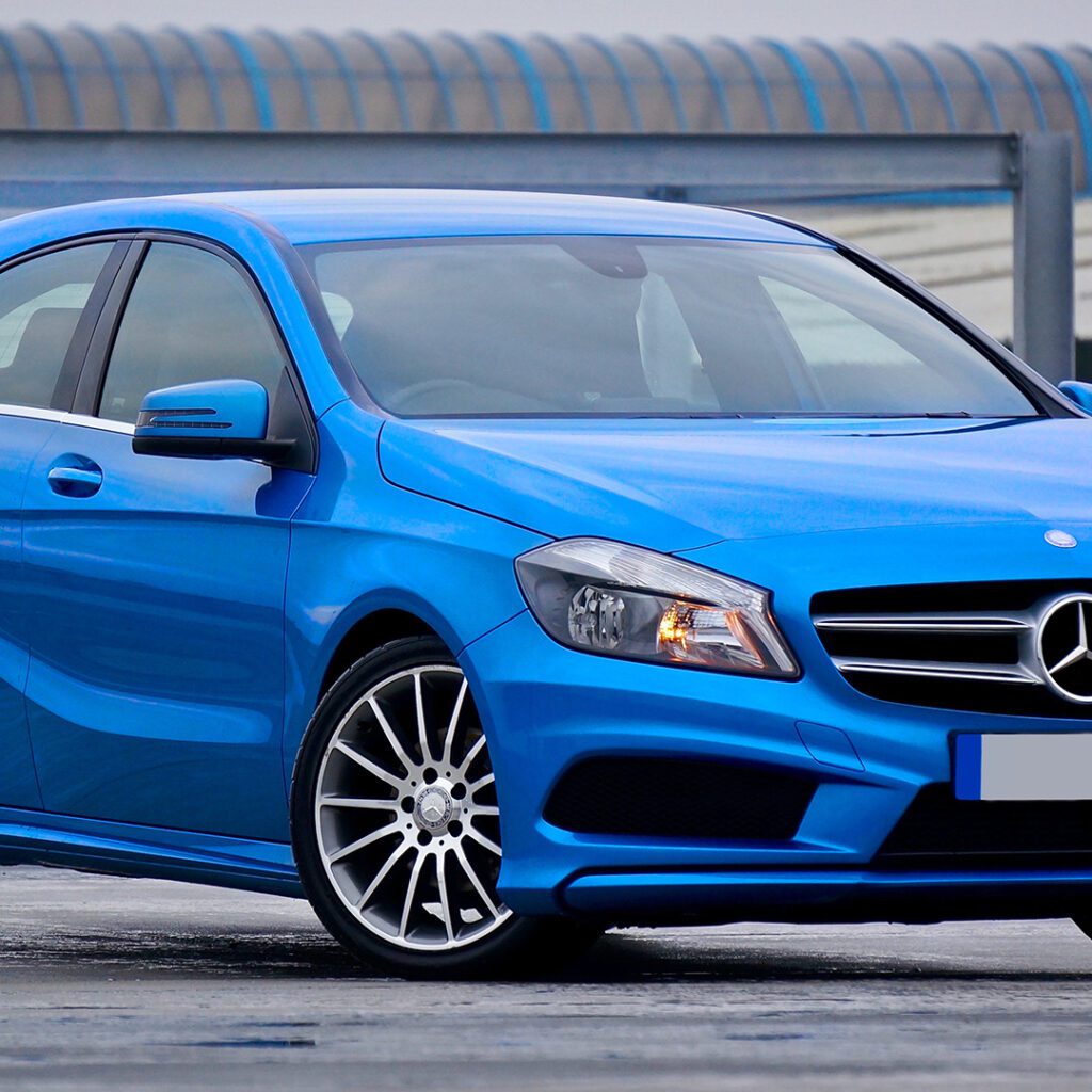 Blue Mercedes-Benz A-Class hatchback on concrete.